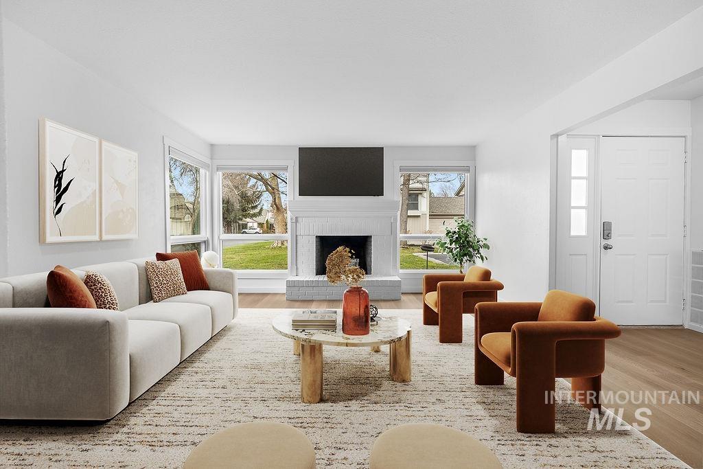 Living room with light wood-style floors, healthy amount of natural light, and a fireplace