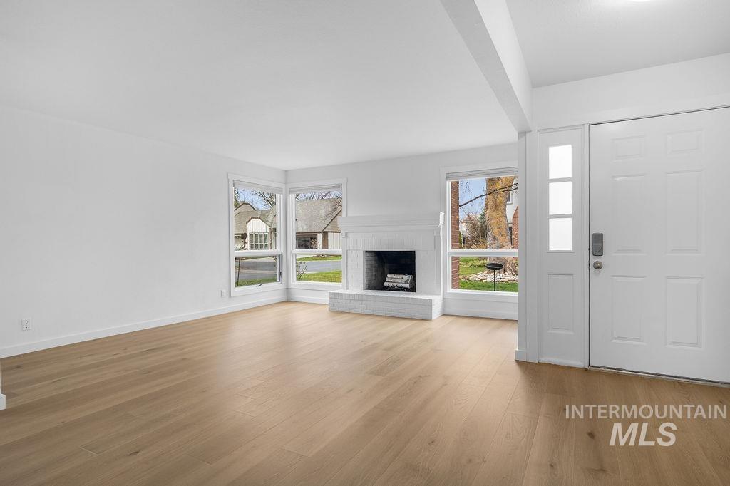 1561 Lenz Lane Boise, ID 83712 - Photo 3 of 29 Unfurnished living room with a brick fireplace and light wood-style flooring