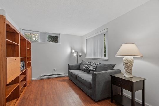 28 Alton Place, Unit A Brookline, MA 02446 - Photo 19 of 23 a living room with furniture a lamp and a window