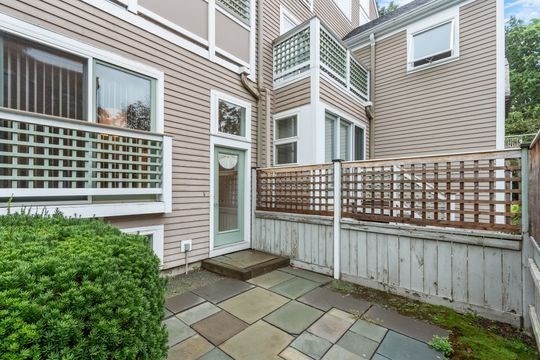 28 Alton Place, Unit A Brookline, MA 02446 - Photo 4 of 23 a view of a brick house with wooden fence