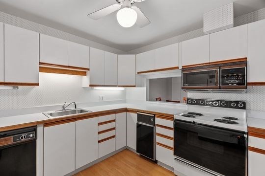 28 Alton Place, Unit A Brookline, MA 02446 - Photo 5 of 23 a kitchen with stainless steel appliances a stove sink and cabinets