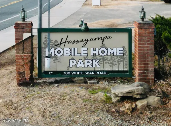 a view of a street sign under a large tree