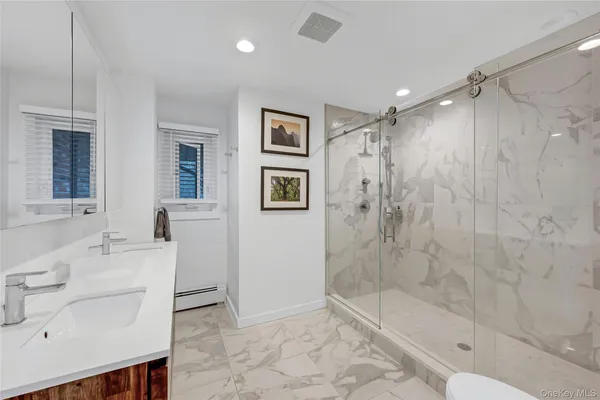 a bathroom with a shower sink and mirror
