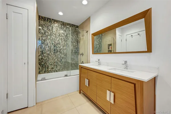 a bathroom with a bathtub a sink and a mirror