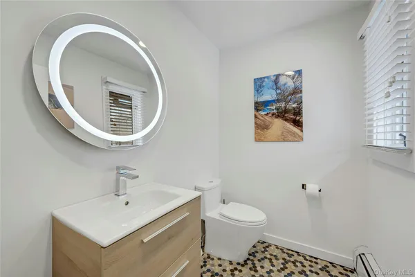a bathroom with a toilet a sink and mirror