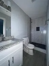 a bathroom with a granite countertop sink toilet and shower