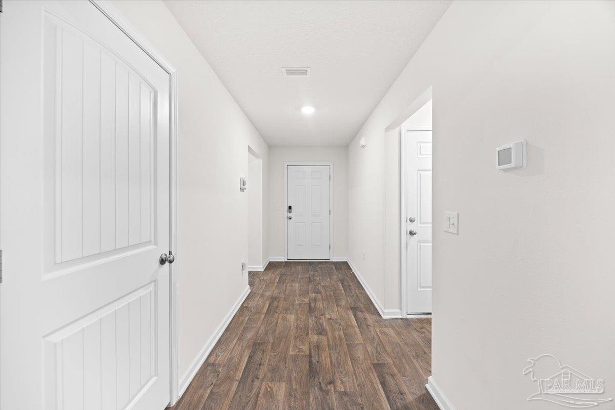 4666 Perception Circle Milton, FL 32570 - Photo 12 of 36 a view of a hallway with wooden floor and a bathroom