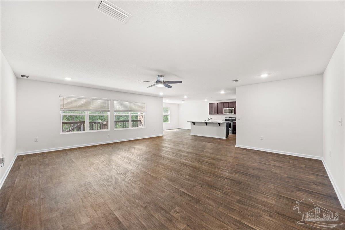 4666 Perception Circle Milton, FL 32570 - Photo 13 of 36 an empty room with wooden floor kitchen view and windows