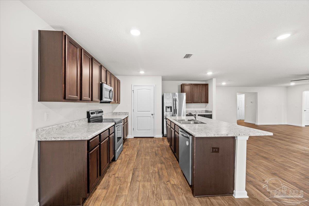 4666 Perception Circle Milton, FL 32570 - Photo 16 of 36 a kitchen with stainless steel appliances granite countertop a sink stove and cabinets