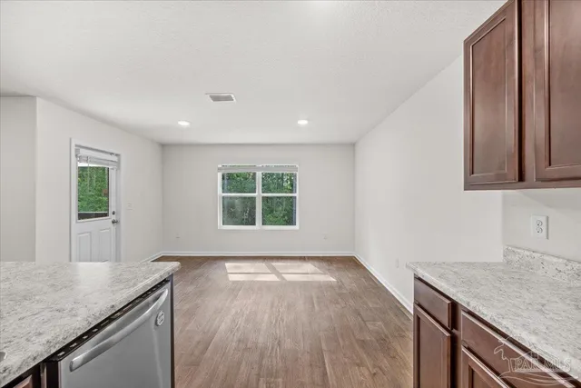 a view of a kitchen with granite countertop a sink and a stove