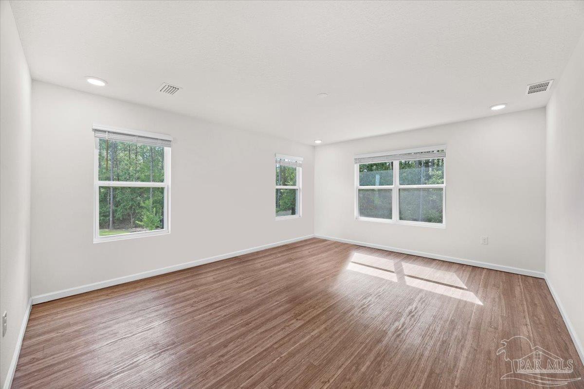 4666 Perception Circle Milton, FL 32570 - Photo 23 of 36 an empty room with wooden floor and windows