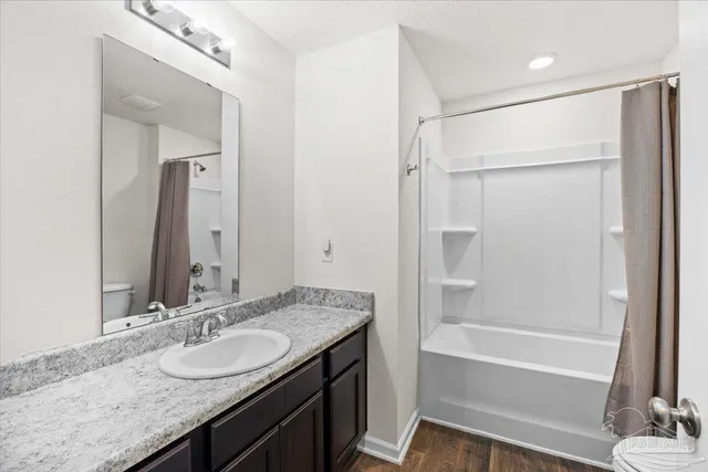 a bathroom with a granite countertop sink mirror and a bathtub
