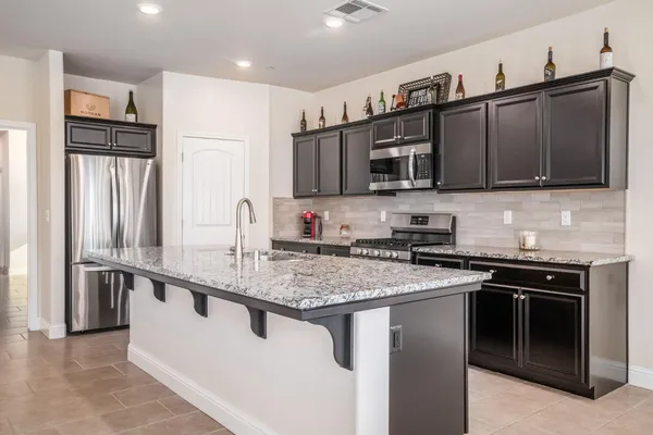 a kitchen with stainless steel appliances granite countertop a sink stove and refrigerator