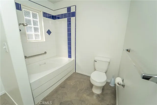 a bathroom with a granite countertop sink toilet and mirror