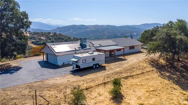 an aerial view of house with yard and mountain view in back