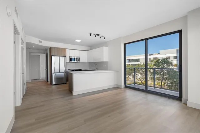a view of a kitchen with wooden floor and electronic appliances