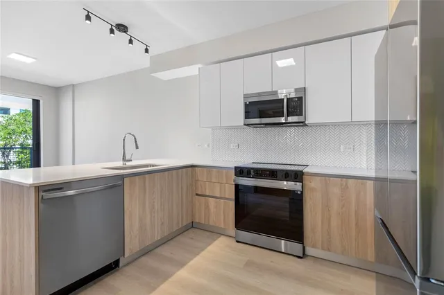 a kitchen with stainless steel appliances granite countertop a sink and a microwave