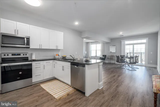 a kitchen with sink cabinets and wooden floor
