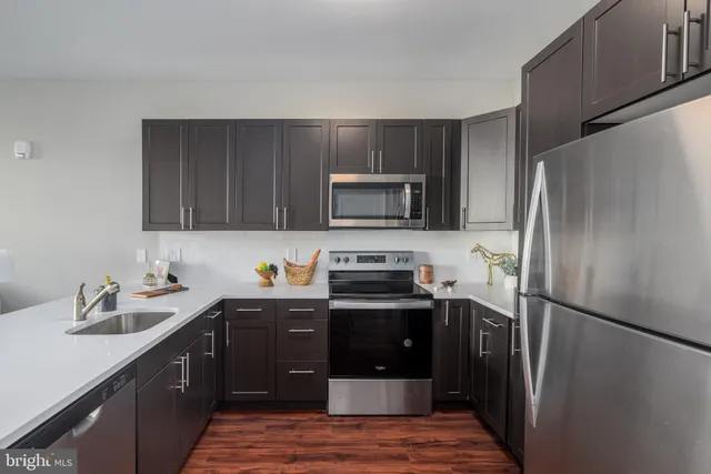a kitchen with a sink refrigerator and microwave