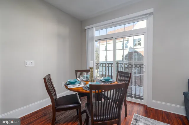 a dining room with furniture window and wooden floor