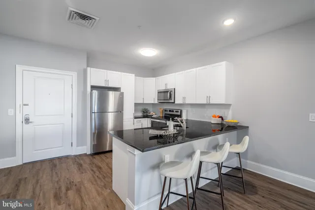 a kitchen with refrigerator cabinets and wooden floor