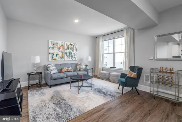 a living room with furniture and a flat screen tv with wooden floor