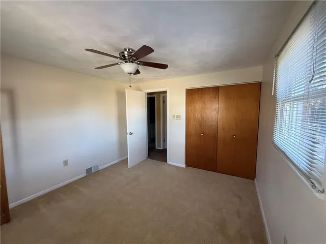 a view of a livingroom with a ceiling fan and window