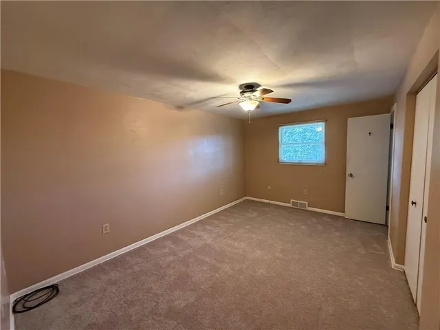an empty room with a empty space and a ceiling fan