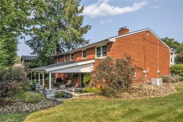 a view of house with yard and sitting area