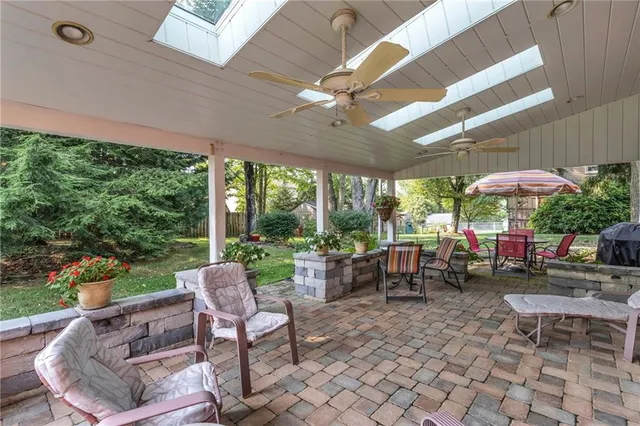 a view of a patio with a table and chairs under an umbrella