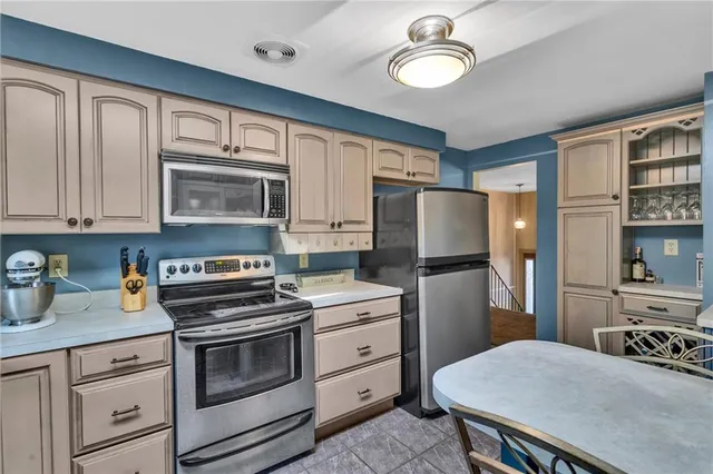 a kitchen with cabinets stainless steel appliances and wooden floor