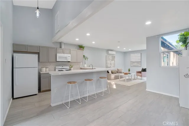 a kitchen with stainless steel appliances a table and chairs in it
