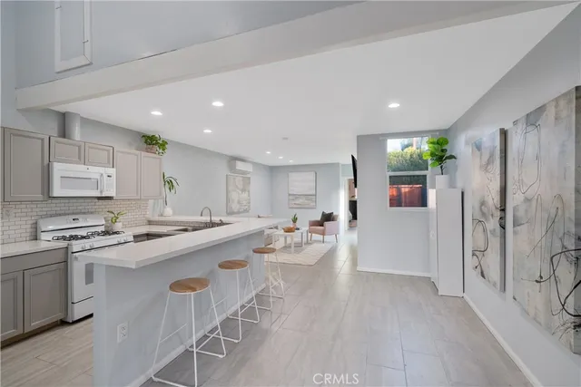 a kitchen with a sink a stove a refrigerator and white cabinets