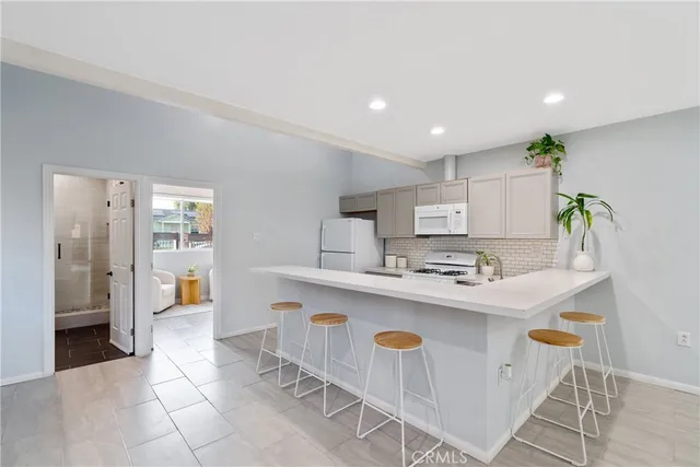 a living room with kitchen island granite countertop furniture and a potted plant