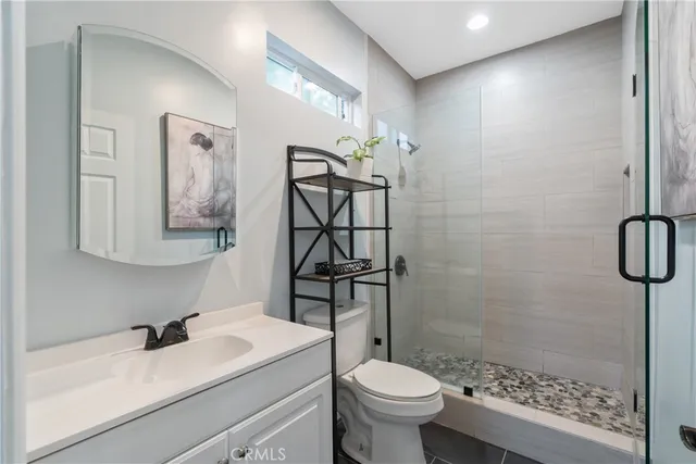 a bedroom with a bed and a clock on the dresser