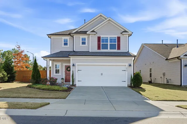 a view of a white house with a yard and plants