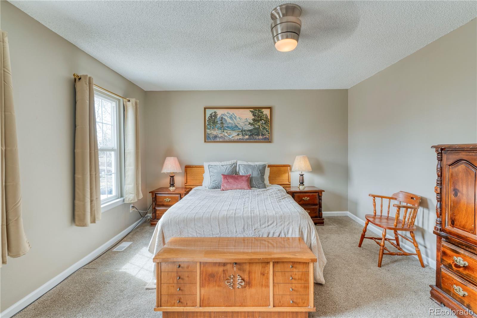 6723 East Rustic Drive Parker, CO 80138 - Photo 17 of 32 a bedroom with a bed a dresser and next to a window
