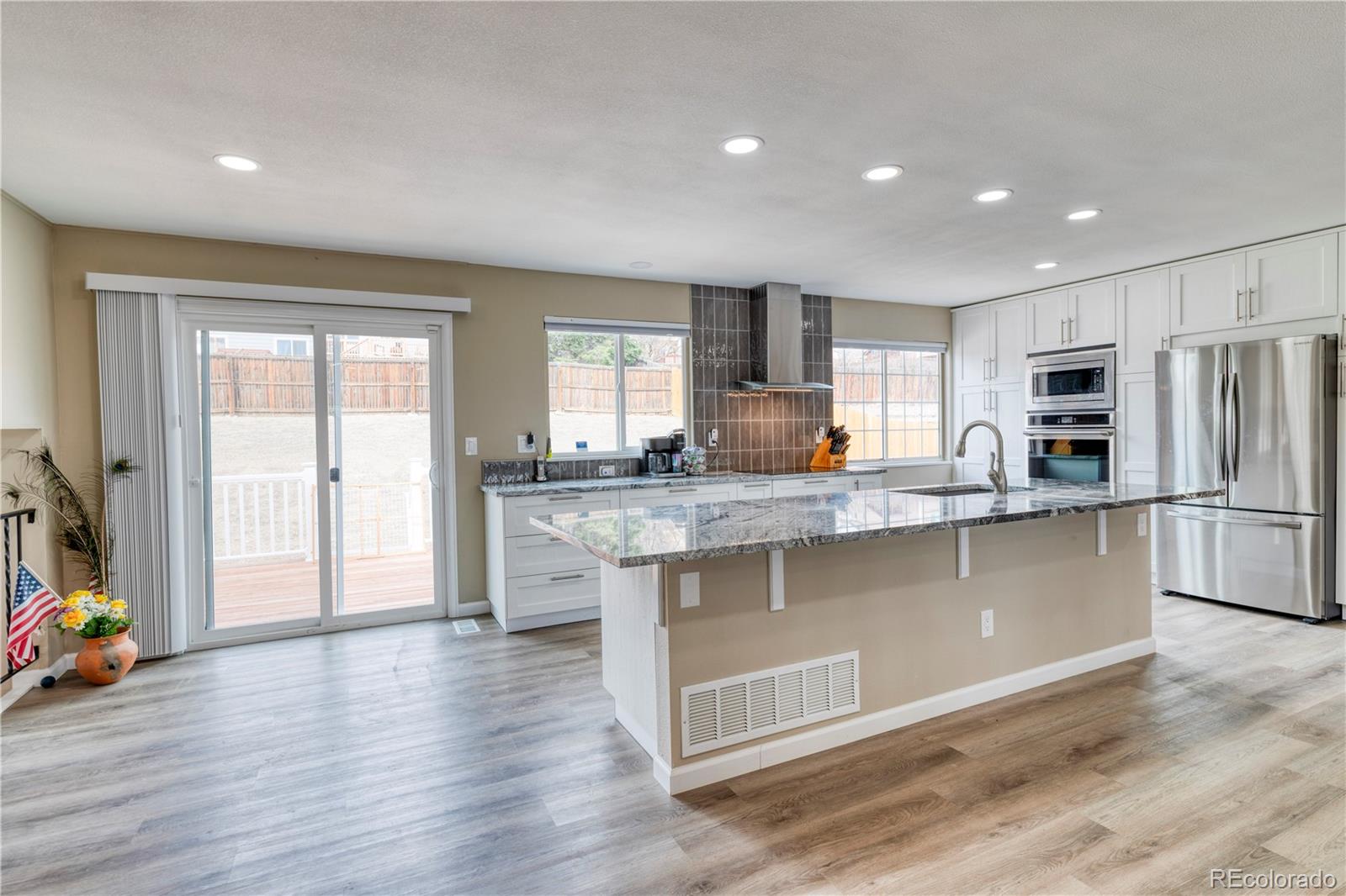 6723 East Rustic Drive Parker, CO 80138 - Photo 8 of 32 a kitchen with stainless steel appliances granite countertop a stove a sink and a refrigerator with wooden floor