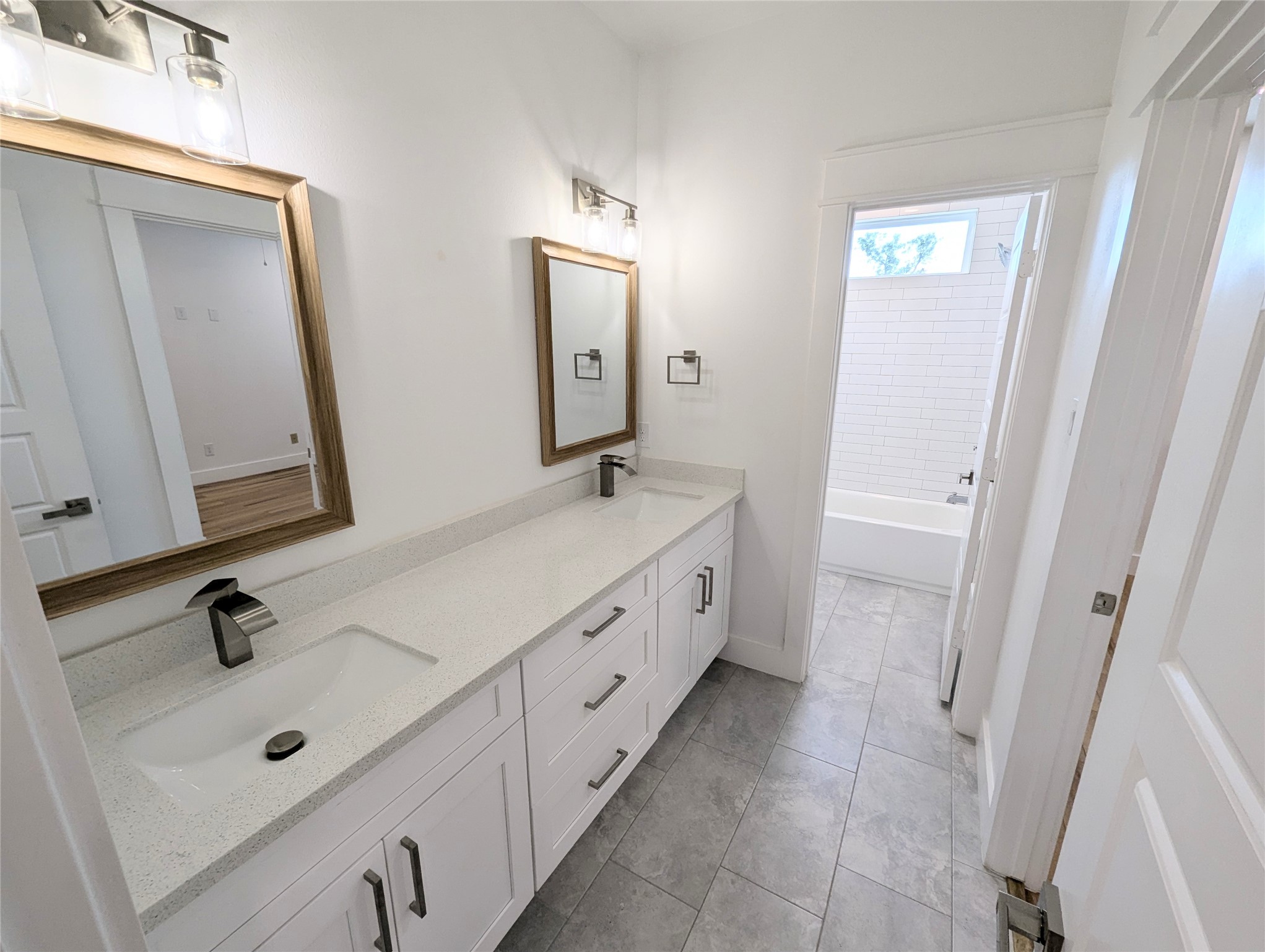 4913 Fisk Street Houston, TX 77009 - Photo 23 of 27 a spacious bathroom with a double vanity sink a mirror and a bathtub
