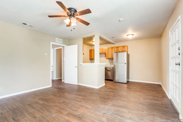 a view of a kitchen with a refrigerator a microwave and a ceiling fan