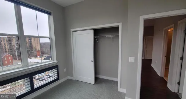 a view of an empty room with a floor to ceiling window and a couch