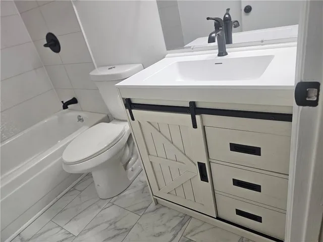 a bathroom with a sink a toilet and bathtub