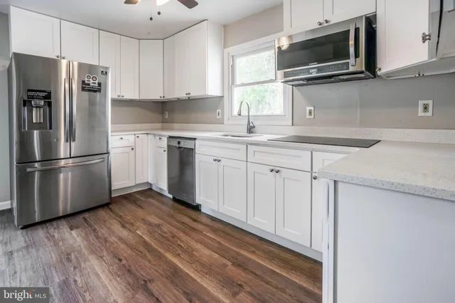 a view of an empty room with wooden floor and closet