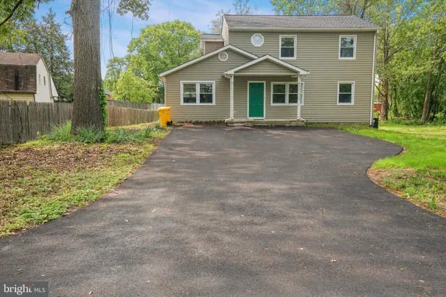 a front view of a house with a yard and trees