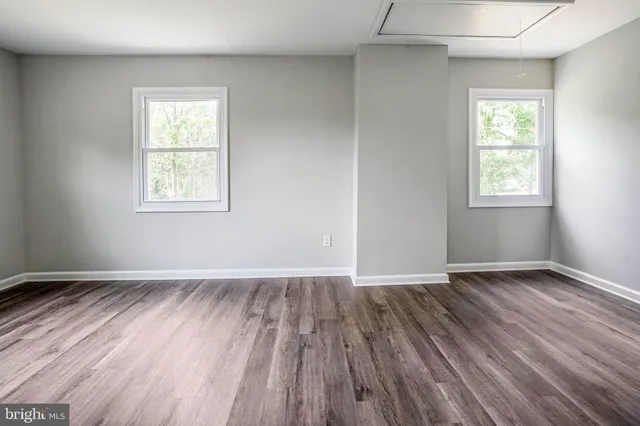 a view of a room with wooden floor a ceiling fan and window