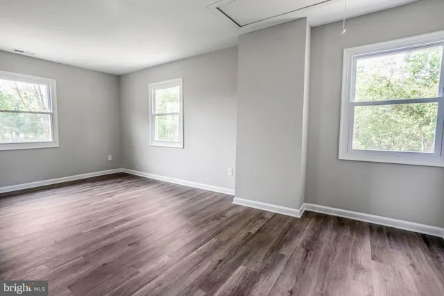 an empty room with wooden floor and a window