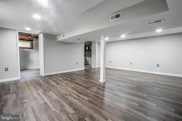 a view of a room with wooden floor and a bathroom