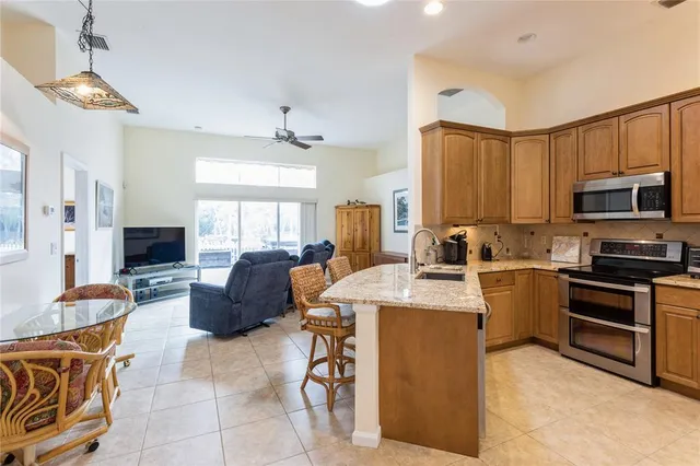 a open kitchen with stainless steel appliances granite countertop a stove refrigerator and cabinets