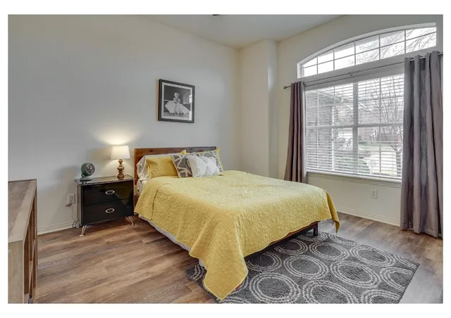 a bedroom with a bed and a large window