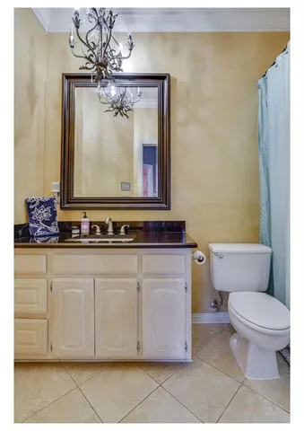 a bathroom with a granite countertop toilet sink and mirror